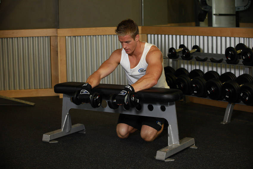 Palms-Down Dumbbell Wrist Curl Over A Bench — starting position