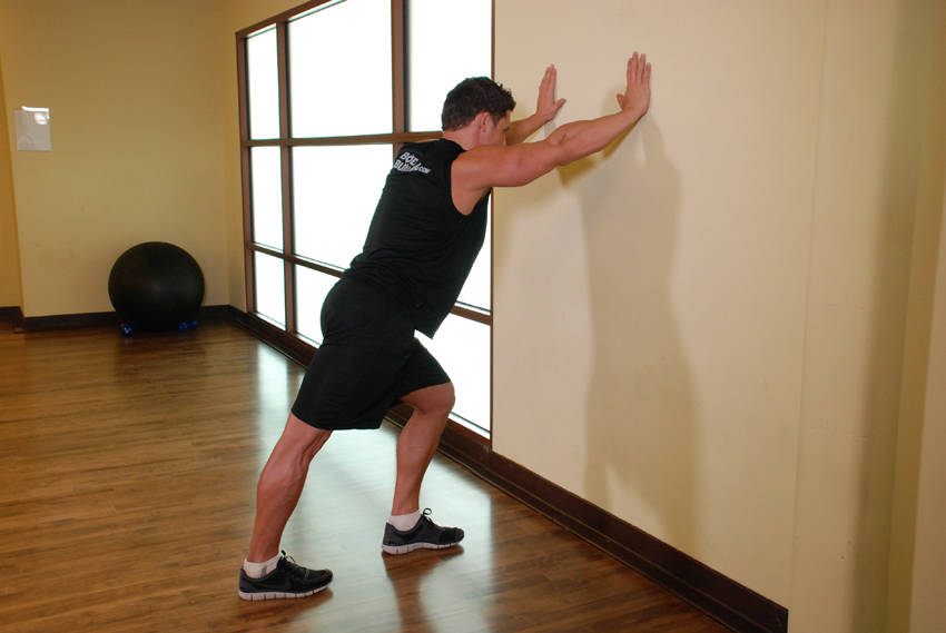 Calf Stretch Hands Against Wall — start